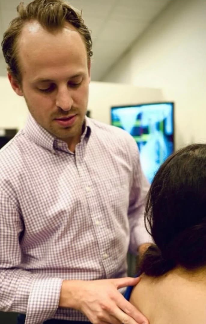 Dr. Chris examining a patient's spine